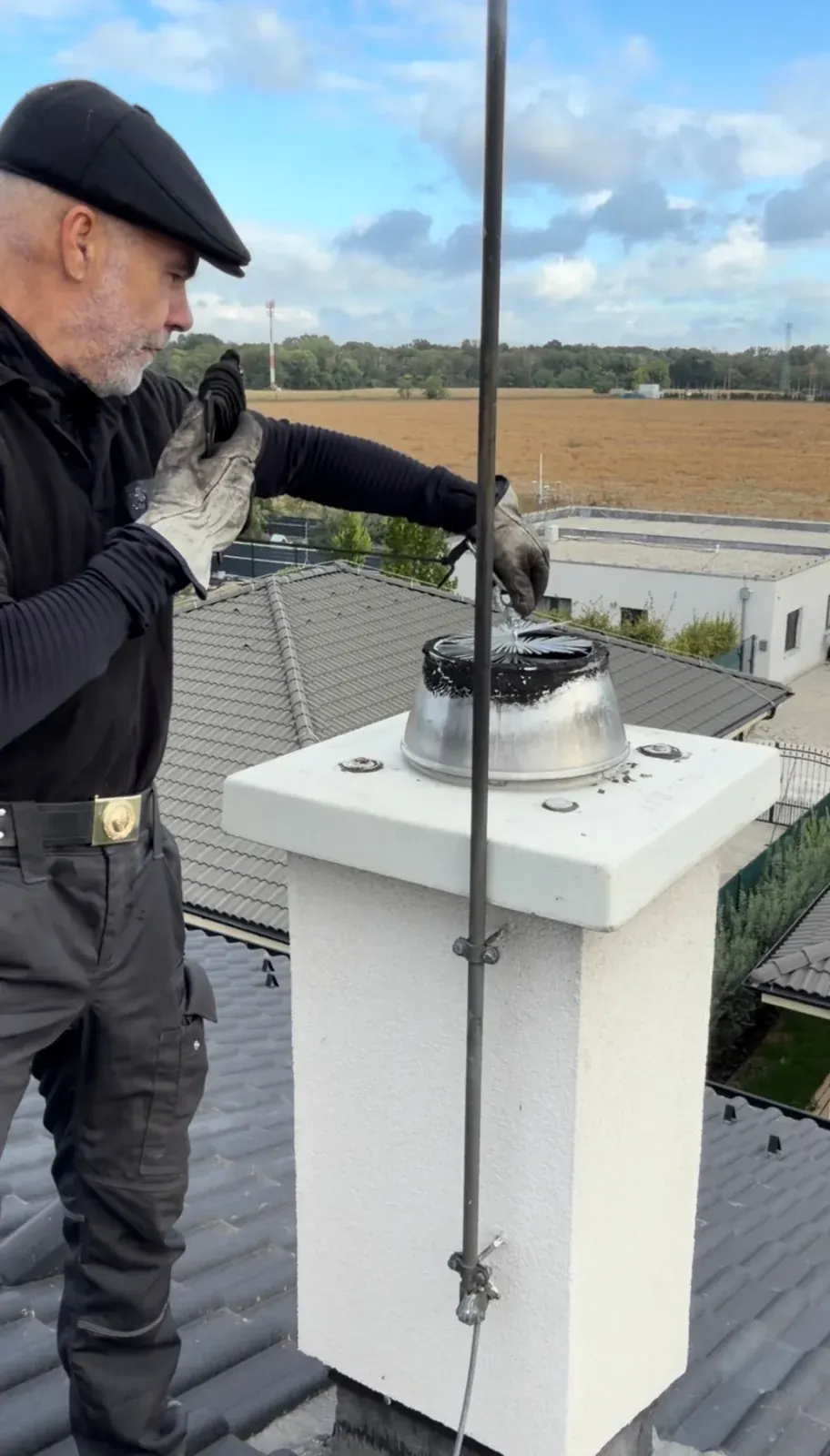 Kominár čistí komín na streche novostavby